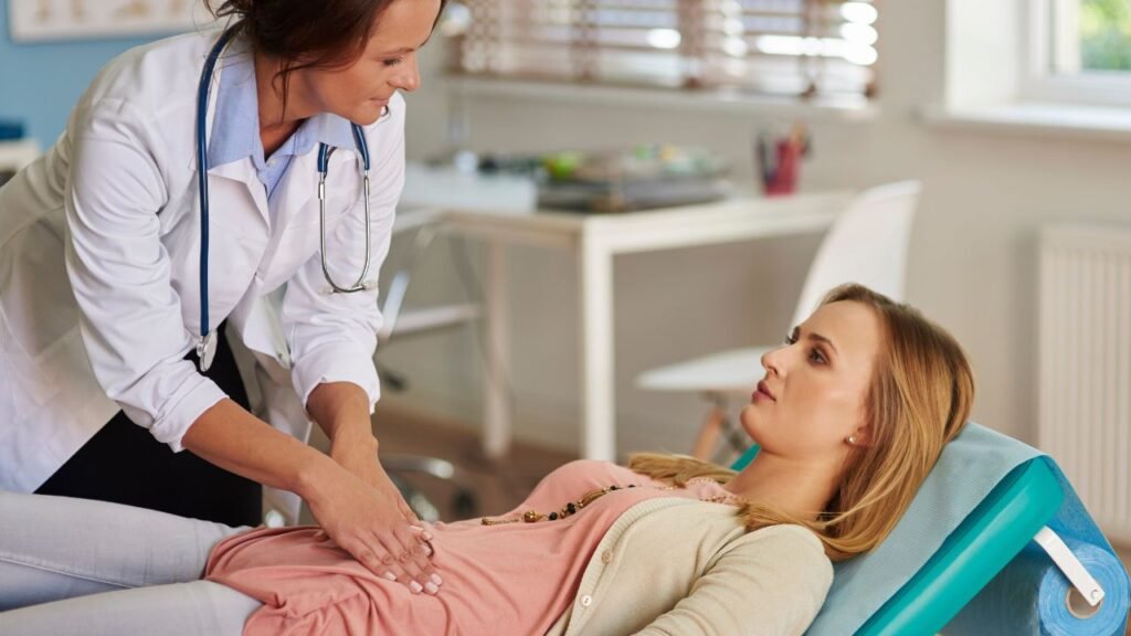 Mulher segurando a barriga com expressão de dor, simbolizando os sintomas da endometriose.