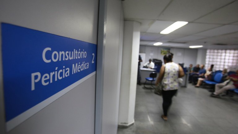 Intérprete de Libras auxiliando pessoa com deficiência auditiva em perícia médica